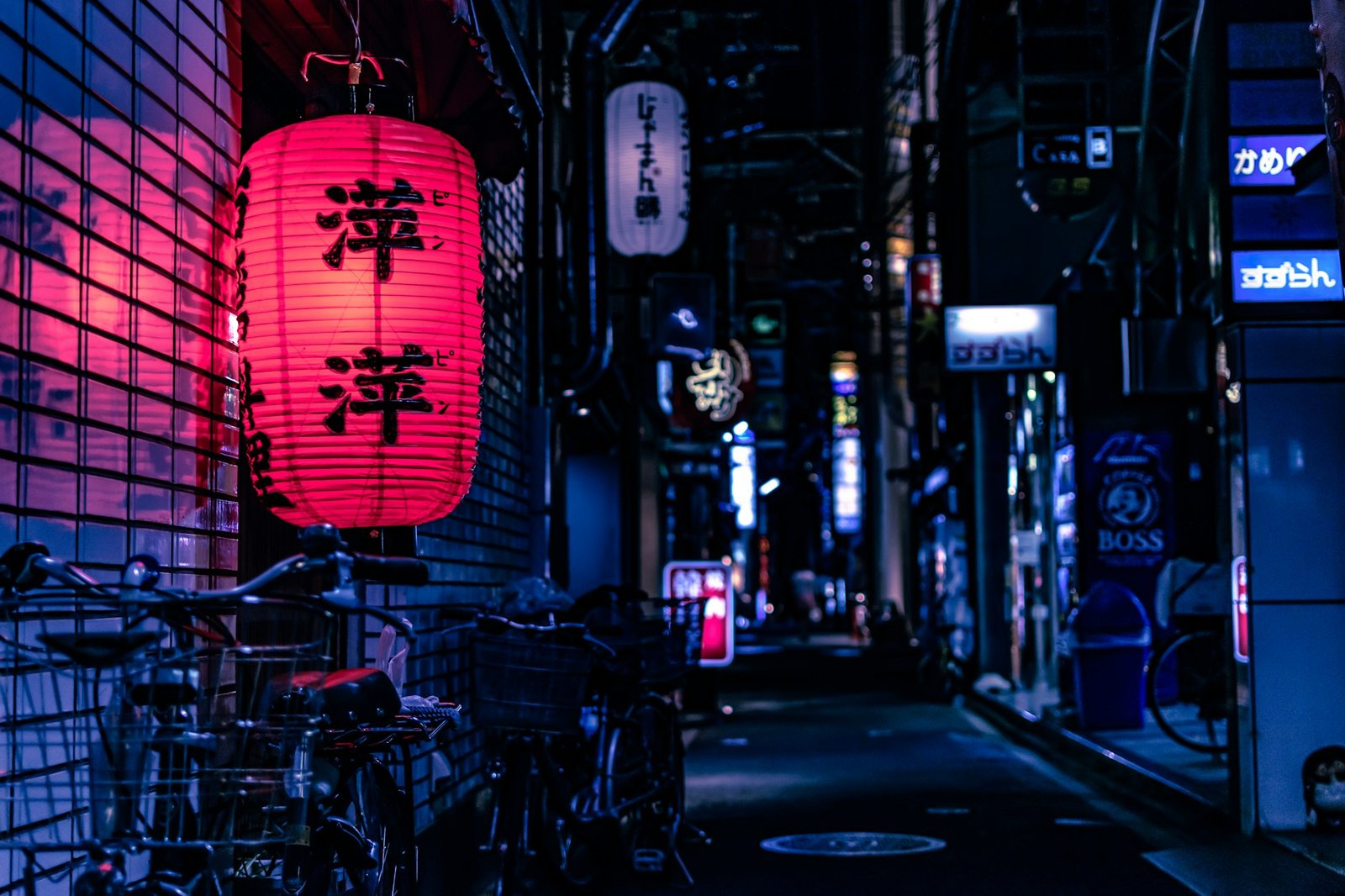 Japanese city street at night with a red lantern